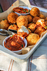 Cheese balls with tomato sauce. Fried snack starter meal. Party food