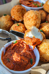 Cheese balls with tomato sauce. Fried snack starter meal. Party food