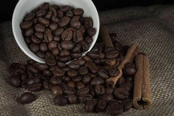 Cup with scattered roasted coffee beans