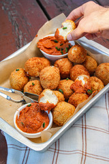 Cheesy balls fried on a baking tray with tomato dip. Close up photo. 