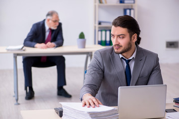 Old boss and his young assistant working in the office