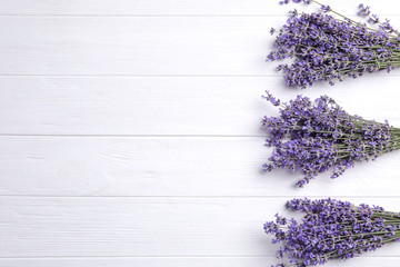 Beautiful lavender flowers on white wooden background, flat lay. Space for text