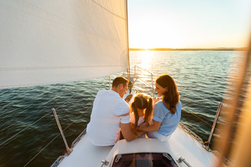 Family Yacht Sailing, Parents And Daughter Sitting On Deck, Back-View