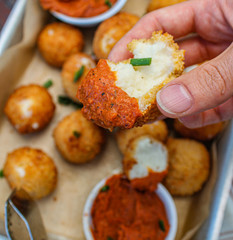 Cheesy balls fried on a baking tray with tomato dip. Close up photo. 