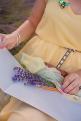 Woman in yellow dress paints in the open air in lavender field