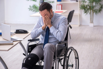 Young leg injured employee working in the office