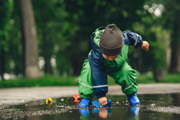 Obraz na płótnie Canvas Kids in a puddle. Child having fun outdoors.