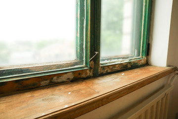 Old window with wooden sill in room