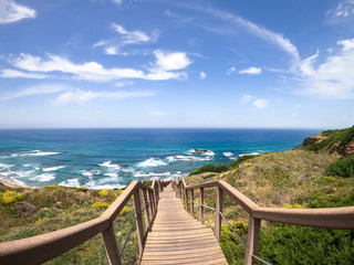 Fototapeta premium Wood stairs on a empty wooden stairway going down. Seascape or view to the ocean. Seaside Landscape. Vacation, holidays, summer feeling