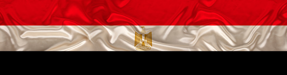 long panorama of the national flag of the state of Egypt with the coat of arms on delicate silk with folds, the concept of tourism, freedom, choice, economy, politics, global world trade