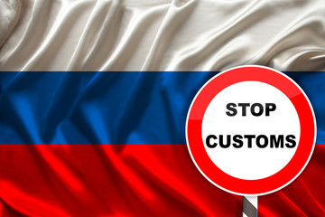 customs sign, stop, attention on the background of the silk national flag of Russia, the concept of border and customs control, violation of the state border, tourism restrictions