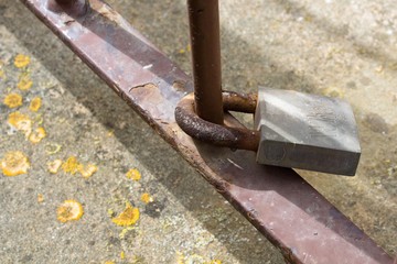 evocative image of a padlock tied to a rusty pole