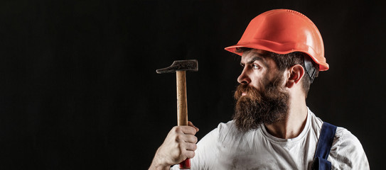 Handyman services. industry, technology, builder man, concept. Bearded man worker with beard, building helmet, hard hat. Hammer hammering. Builder in helmet, hammer, handyman