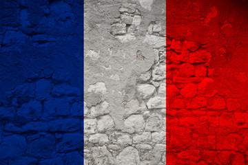 national flag of the state of France on an old stone wall with cracks, the concept of tourism, emigration, economy, politics, global world trade