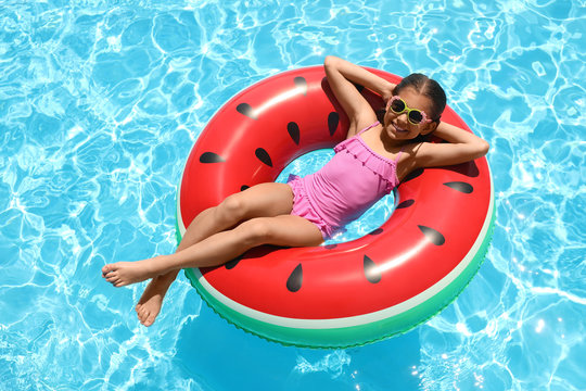 Girl on inflatable ring in swimming pool. summer vacation