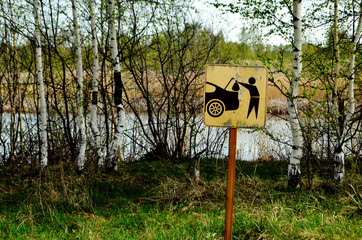 Symbol sign take the trash with you. The sign is installed on the shore of the lake. Ecology. Pollution. The sign stands on the right
