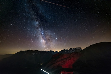 The Milky Way and starry sky on the Alps, Massif des Ecrins, Briancon Serre Chevalier ski resort, France. Panoramic view high mountain range and glaciers