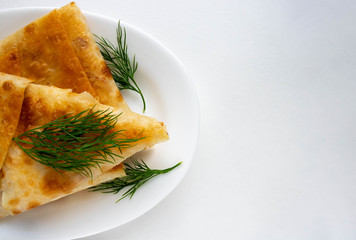 Dill pancakes with cream cheese filling on a white plate. space for your text