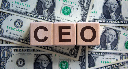 Concept word 'CEO' on cubes on a beautiful background from dollar bills. Business concept.