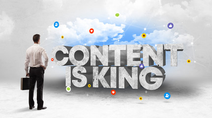 Young businessman standing in front of CONTENT IS KING inscription, social media concept