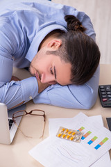 Naklejka premium Sick male employee suffering at workplace