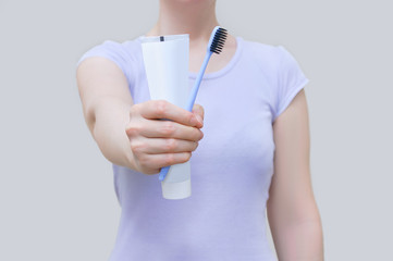 Morning hygiene. Close-up of  toothbrush and paste in  hands of  Caucasian woman.