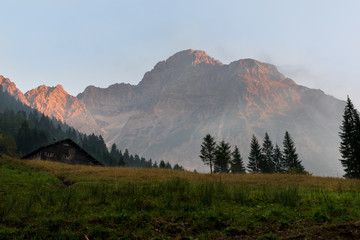 Obraz premium Sunset in Austria, State Vorarlberg with the mountain Widderstein in the background and a old hut in the foreground.