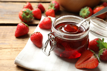 Delicious pickled strawberry jam and fresh berries on wooden table, closeup