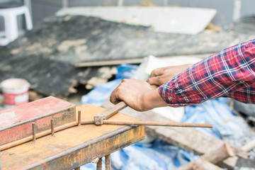 The hands of the builder are bending the iron at site construction