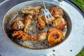 Chicken legs frying in hot oil dish plate