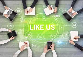 Group of people having a meeting with LIKE US insciption, social networking concept