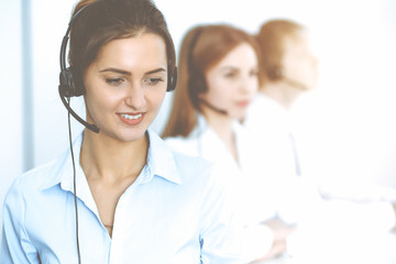 Call center. Focus on beautiful business woman in headset