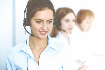 Call center. Focus on beautiful business woman in headset