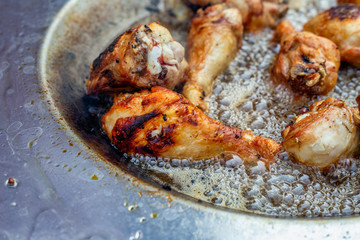 Chicken drumstick frying in hot oil dish plate