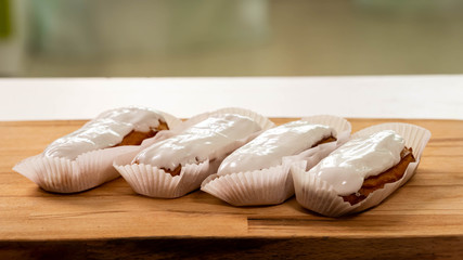 Fototapeta na wymiar Several eclairs with a white filling lie on a cutting Board
