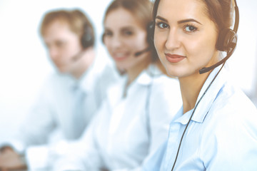 Fototapeta premium Call center. Focus on beautiful business woman in headset