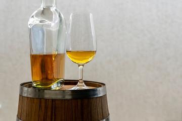 crystal iso glass with cachaça and bottle in wooden barrel. Space for text. cachaça day is september 13