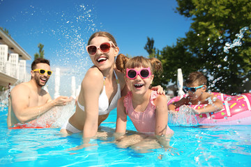 Obraz na płótnie Canvas Happy family having fun in swimming pool