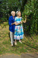 Fototapeta premium Portrait of two smiling elderly woman. A photo on the nature background