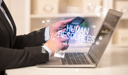 Side view of a business person working on laptop with HUMAN RESOURCES inscription, modern business concept