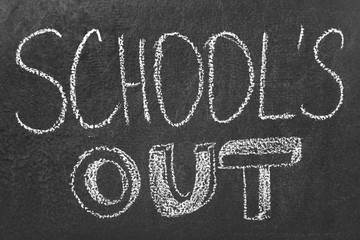 Fototapeta na wymiar Text School's Out written on black chalkboard. Summer holidays