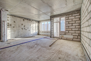 Unfinished construction empty room. Walls from lightweight aggregate concrete blocks with empty...