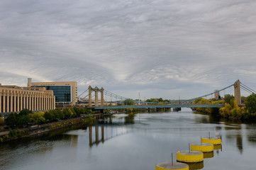 Obraz premium Hennepin Avenue suspension brdige over the Mississippi river at Minneapolis with Post Office and Federal Reserve Bank