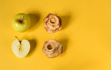 Fototapeta na wymiar Natural apple chips on a yellow background. Healthy vegan vegetarian fruit snacks. Organic food for wellness. It's time to lose weight