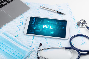 Tablet pc and medical stuff with PILL inscription, prevention concept