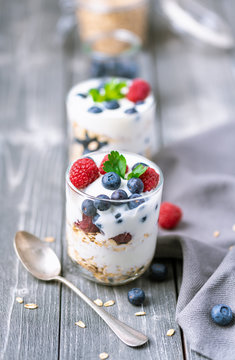 White yogurt with granola and blueberries and raspberries on the top.