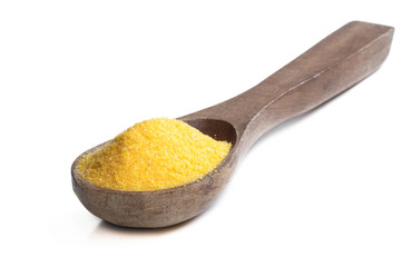 Corn grits polenta in wooden spoon isolated on white
