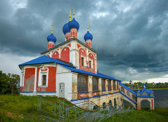Fototapeta na wymiar The old church of the Icon of the Mother of God Kazanskaya under the thunderstorm sky. Tutaev, Russia