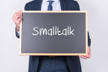 Geschäftsmann hält eine Tafel mit dem Schlagwort Smalltalk