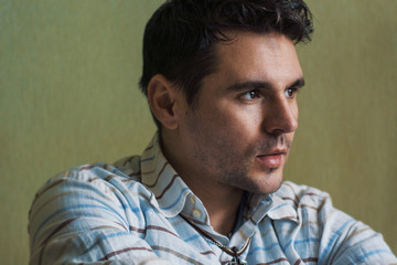 Fototapeta premium Handsome young man posing on dark background. Portrait of satisfied businessman against wall. Close up face of fashionable man